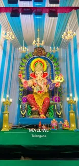 Colorful Ganesh idol with vibrant backdrop in temple setting.