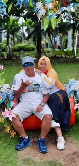 Couple sitting on a garden bench surrounded by vibrant flowers.