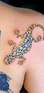 Colorful gecko tattoo with intricate patterns on a shoulder.