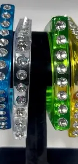 Colorful gemstone bangles on a display stand.