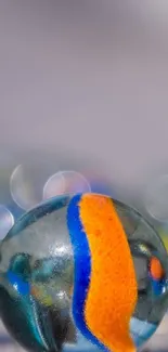 Close-up of colorful glass marbles with vibrant orange and blue details.