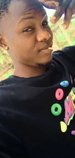 Young man in a colorful t-shirt outdoors.