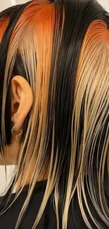 Colorful sleek hair art with black, orange, and blonde tones.