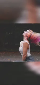 Woman with vibrant hair in motion against a dark blurred backdrop.