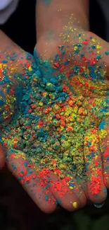 Bright pigments in hands wallpaper featuring vibrant blue, yellow, and pink colors.