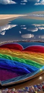 A heart of rainbow colors on a reflective beach with clear skies above.