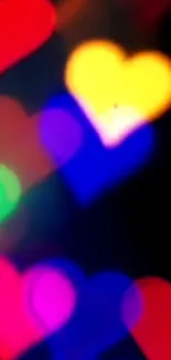 Colorful bokeh hearts with black background.