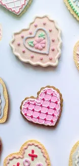 Heart-shaped cookies with pink icing on a pastel wallpaper.