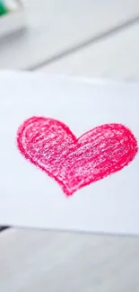 Colorful heart crayon drawing on wooden background.