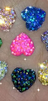 Seven colorful heart-shaped gems on a hand.