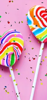 Heart-shaped rainbow lollipop on pink background.