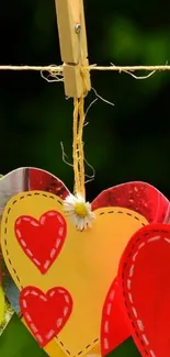 Colorful hearts hanging on a line with a green background.