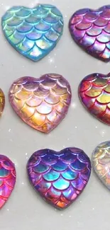 Colorful, iridescent heart shapes with scalelike patterns on a wallpaper.