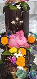 Colorful floral-adorned Shivling on marble background.