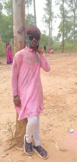 Colorful Holi celebration in nature setting with vibrant attire.