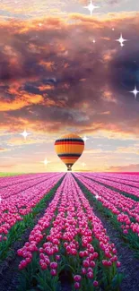 Hot air balloon over pink tulip fields at sunset.