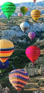 Colorful hot air balloons over a scenic, rocky landscape.