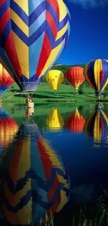 Colorful hot air balloons reflecting on a tranquil lake under a vibrant blue sky.