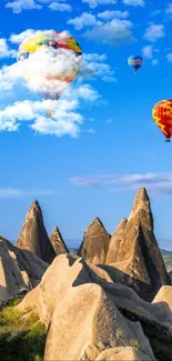 Colorful hot air balloons over rock formations.