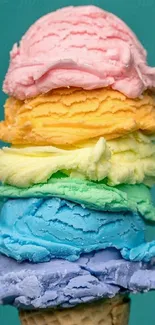 Stack of rainbow ice cream scoops on a cone with teal background.