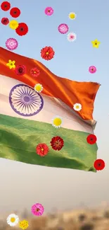 Indian flag with colorful flowers on a clear sky background.