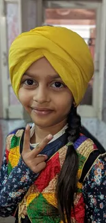 Kid with yellow turban and colorful attire.