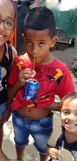 Children sipping drinks outdoors with smiles.