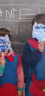 Kids in colorful masks creating art in a classroom.