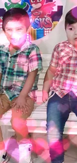 Two smiling kids wearing plaid shirts with colorful background.