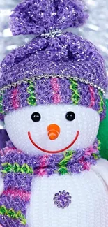 Colorful knitted snowman with a purple hat.