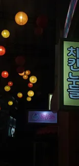 Vibrant lanterns and neon sign lights on a dark city street at night.