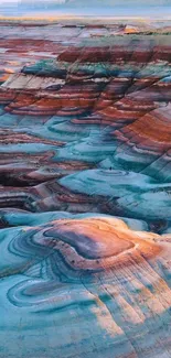 Colorful layered rock formation wallpaper with vibrant blue, orange, and brown hues.