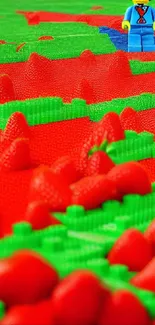 Lego figure amidst green and red Lego blocks with strawberries.