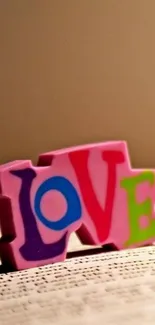 Colorful 'Love' text on a beige background.