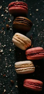 Elegant arrangement of colorful macarons on a dark textured background.