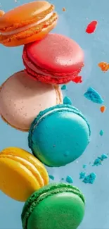 Colorful macarons scattered on light blue background wallpaper.