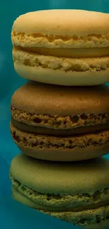 Stack of colorful macarons on a teal background.