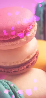 Colorful macarons stacked on a pink background wallpaper.