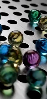 Vibrant marbles on a perforated metal background.