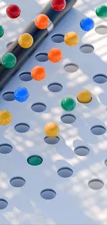 Colorful marbles on white surface with shadows.