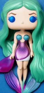 Whimsical mermaid figurine with green hair on a blue background.