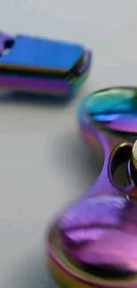 Close-up of a colorful, metallic fidget spinner on a mobile wallpaper.