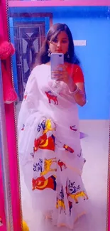 Colorful traditional saree in mirror selfie with blue background.