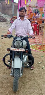 Man on a motorcycle at a vibrant celebration event.