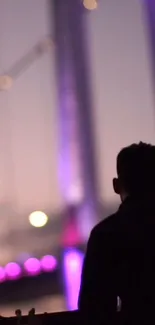 Silhouette with colorful night bridge bokeh.