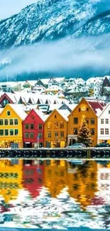 Colorful Nordic village with snowy mountain backdrop and reflection.