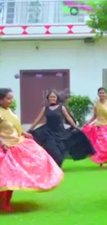 Women dancing outdoors in vibrant dresses.