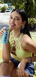 Woman with drink enjoying sunny outdoor scene.