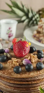 Stack of pancakes with berries and nuts on top.