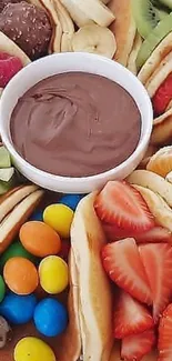 A vibrant pancake dessert platter with fruits and chocolate dip.